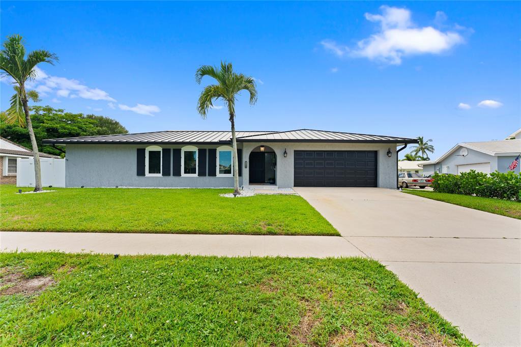22111 Serenata Circle West Boca Raton, FL 33433 - Photo 2 of 18 a front view of a house with a garden and yard