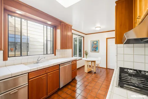 a large white kitchen with a large window