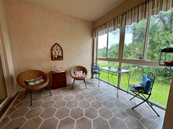 a living room with furniture and a floor to ceiling window
