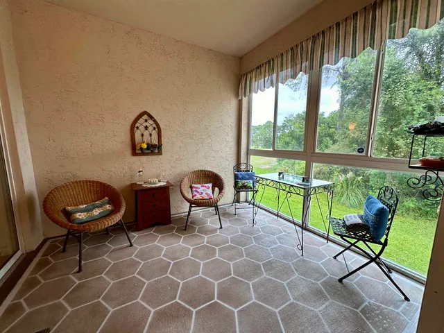 a living room with furniture and a floor to ceiling window