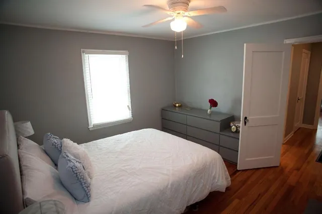 a bedroom with a bed and wooden floor
