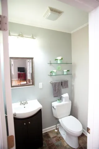 a bathroom with a toilet a sink and mirror