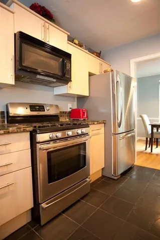 a kitchen with stainless steel appliances granite countertop a stove microwave and refrigerator