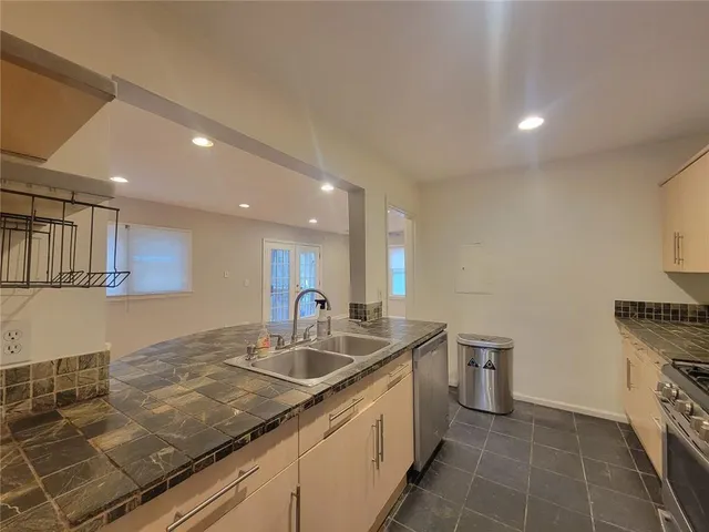 a kitchen with granite countertop a sink and a stove