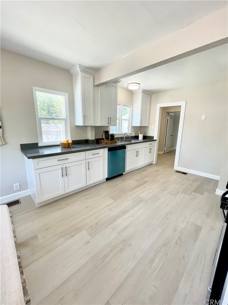 3824 Spruce Street Riverside, CA 92501 - Photo 1 of 1 a large white kitchen with stainless steel appliances granite countertop a stove and a sink