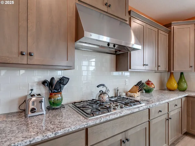 a kitchen with stainless steel appliances granite countertop a sink a stove and cabinets
