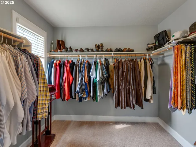 a view of walk in closet with clothes and shoes