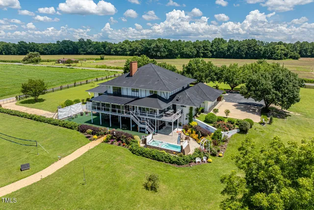 an aerial view of a house with a garden and lake view