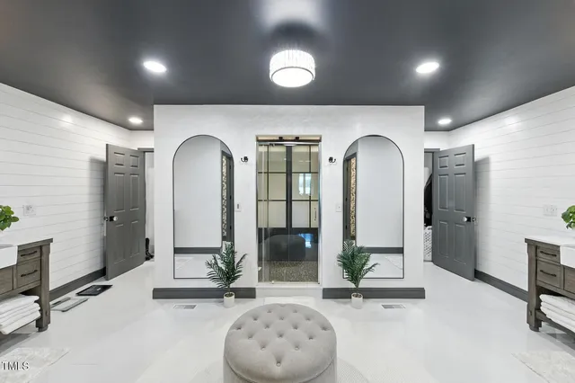 a bedroom with two beds and a large mirror next to a window