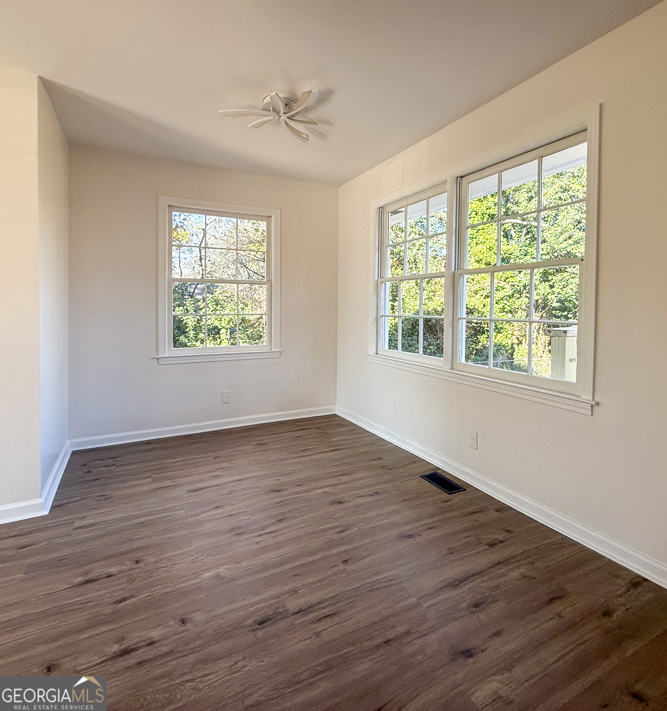 239 East Doyle Street Toccoa, GA 30577 - Photo 6 of 20 a view of an empty room with wooden floor and a window
