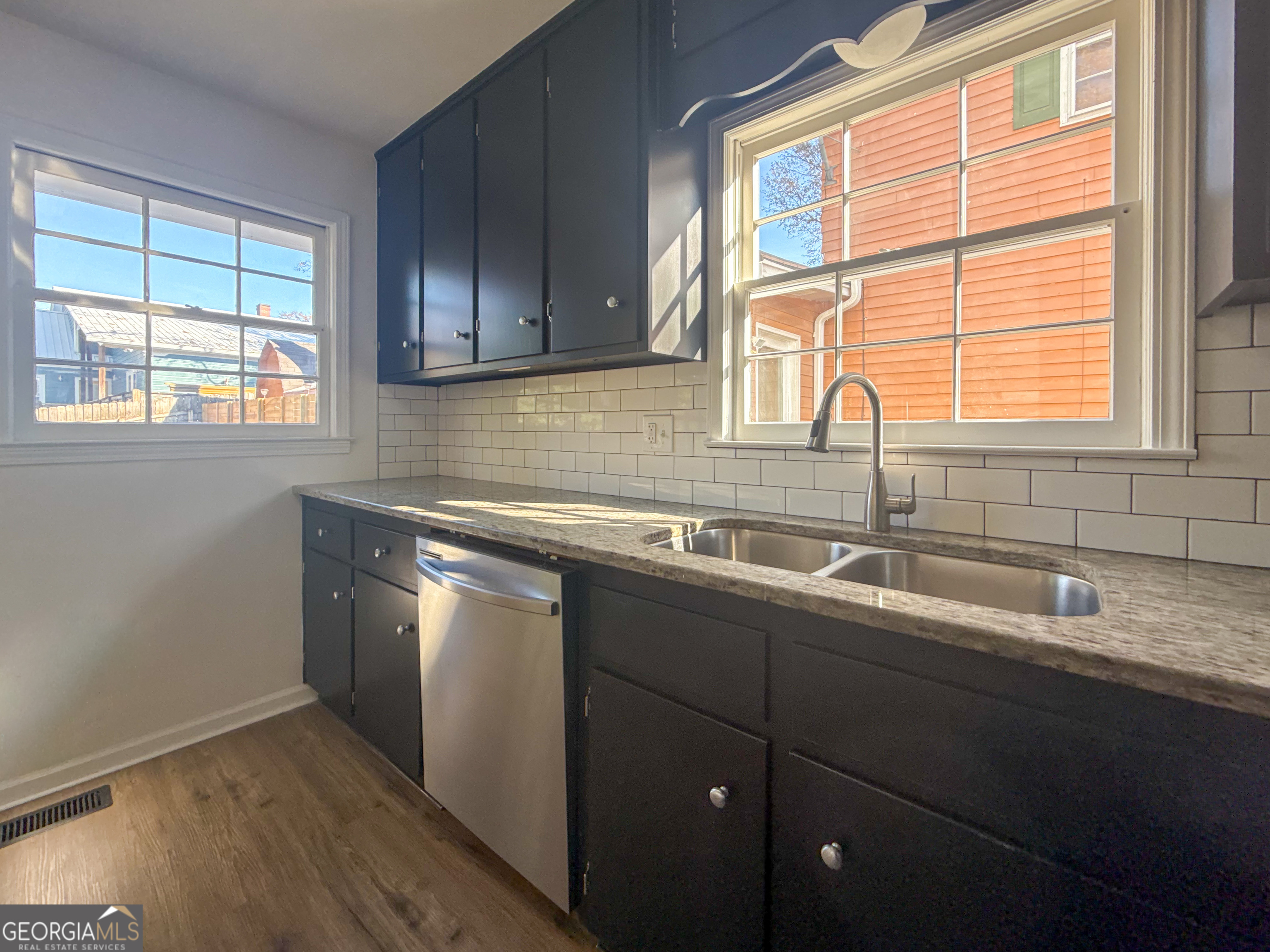 239 East Doyle Street Toccoa, GA 30577 - Photo 8 of 20 a kitchen with stainless steel appliances wooden cabinets a sink and a window