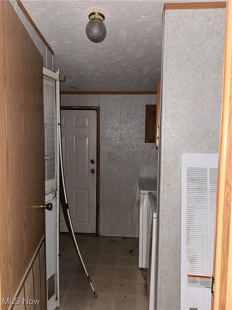3690 Anderson Anthony Road Leavittsburg, OH 44430 - Photo 9 of 18 Laundry room with crown molding, a heating unit, light floors, and a textured ceiling