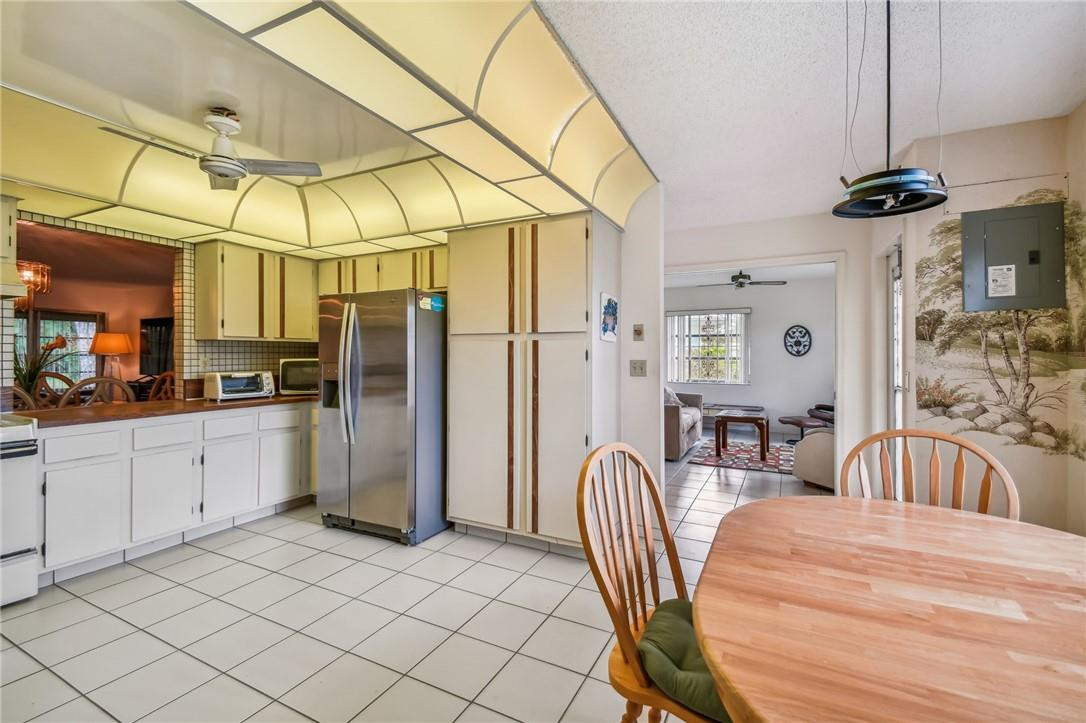 5348 Privet Place, Unit D Delray Beach, FL 33484 - Photo 11 of 60 a kitchen with stainless steel appliances granite countertop a sink a stove a refrigerator a washer dryer and a dining table