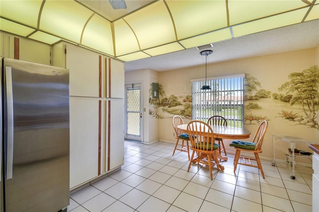 5348 Privet Place, Unit D Delray Beach, FL 33484 - Photo 13 of 60 a dining room filled a chandelier and kitchen view