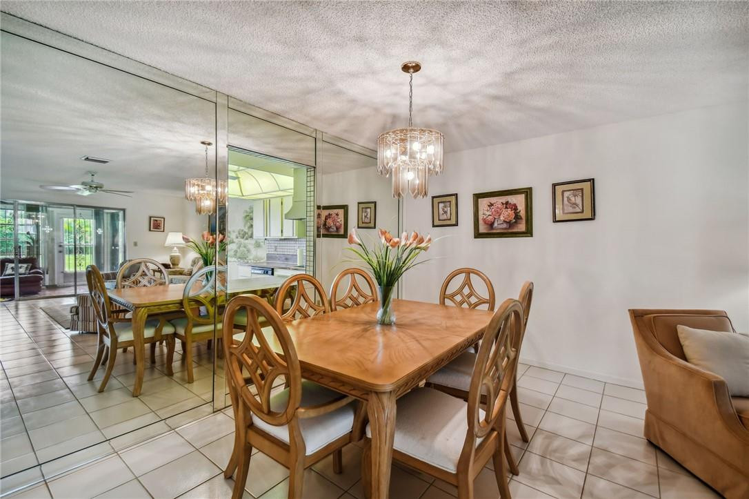 5348 Privet Place, Unit D Delray Beach, FL 33484 - Photo 18 of 60 a dining room with furniture and chandelier