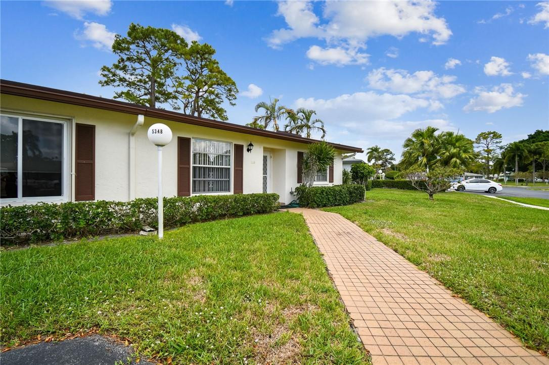 5348 Privet Place, Unit D Delray Beach, FL 33484 - Photo 2 of 60 a front view of a house with a yard