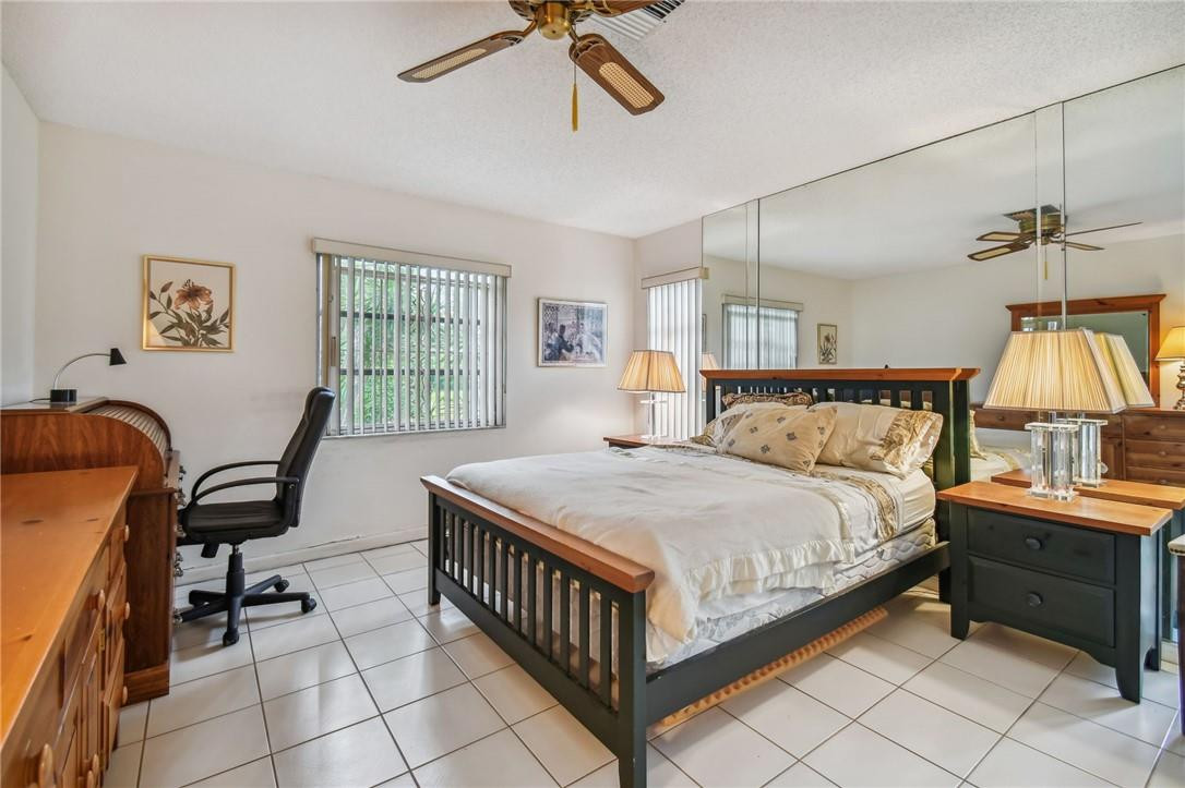 5348 Privet Place, Unit D Delray Beach, FL 33484 - Photo 27 of 60 a bedroom with a bed and a table in it