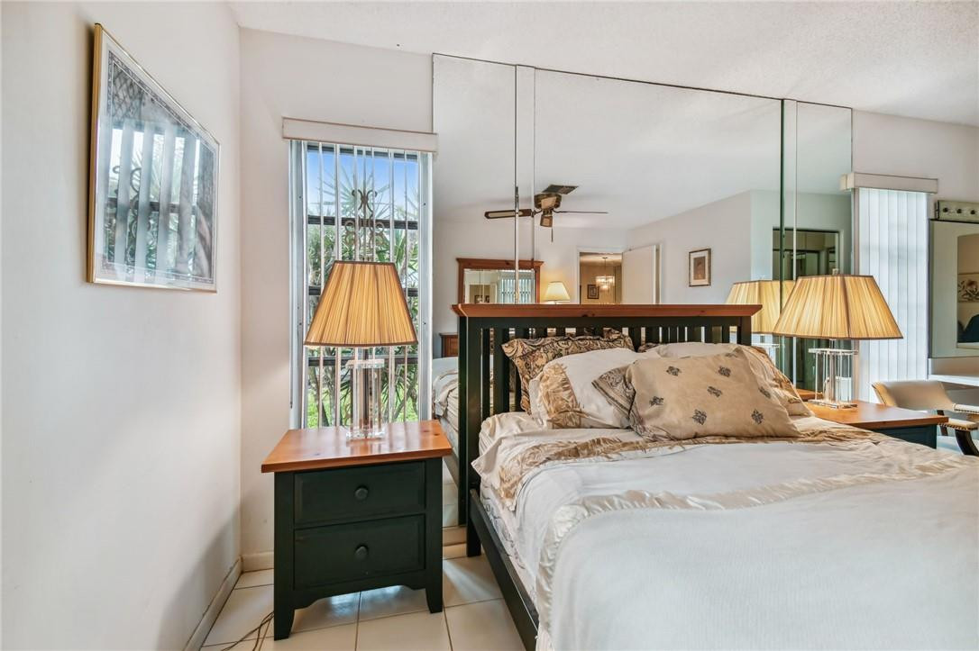 5348 Privet Place, Unit D Delray Beach, FL 33484 - Photo 28 of 60 a bed sitting in a bedroom next to a window