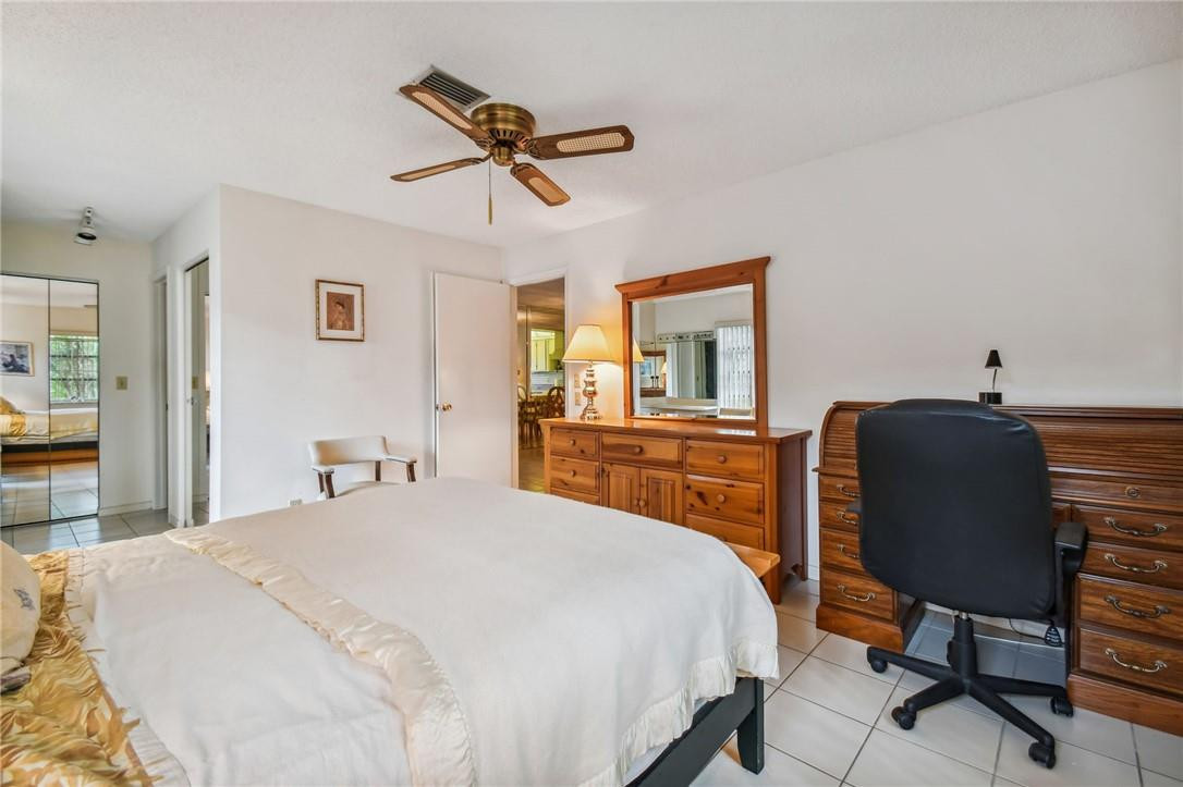 5348 Privet Place, Unit D Delray Beach, FL 33484 - Photo 29 of 60 a bedroom with a bed and a chair