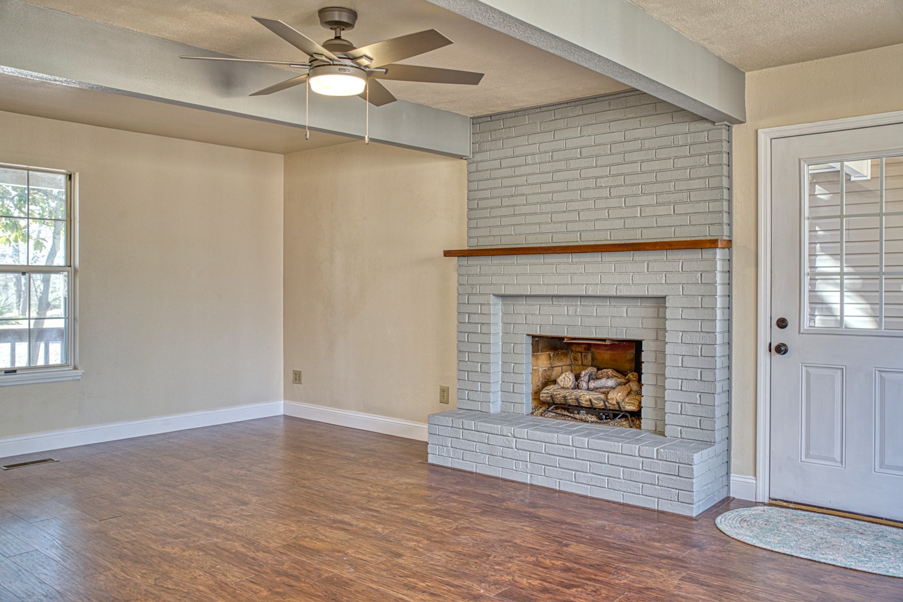 LIVING ROOM WITH GAS LOG FIREPLACE, NEW WOOD FLOORING, BEAMED CEILINGS