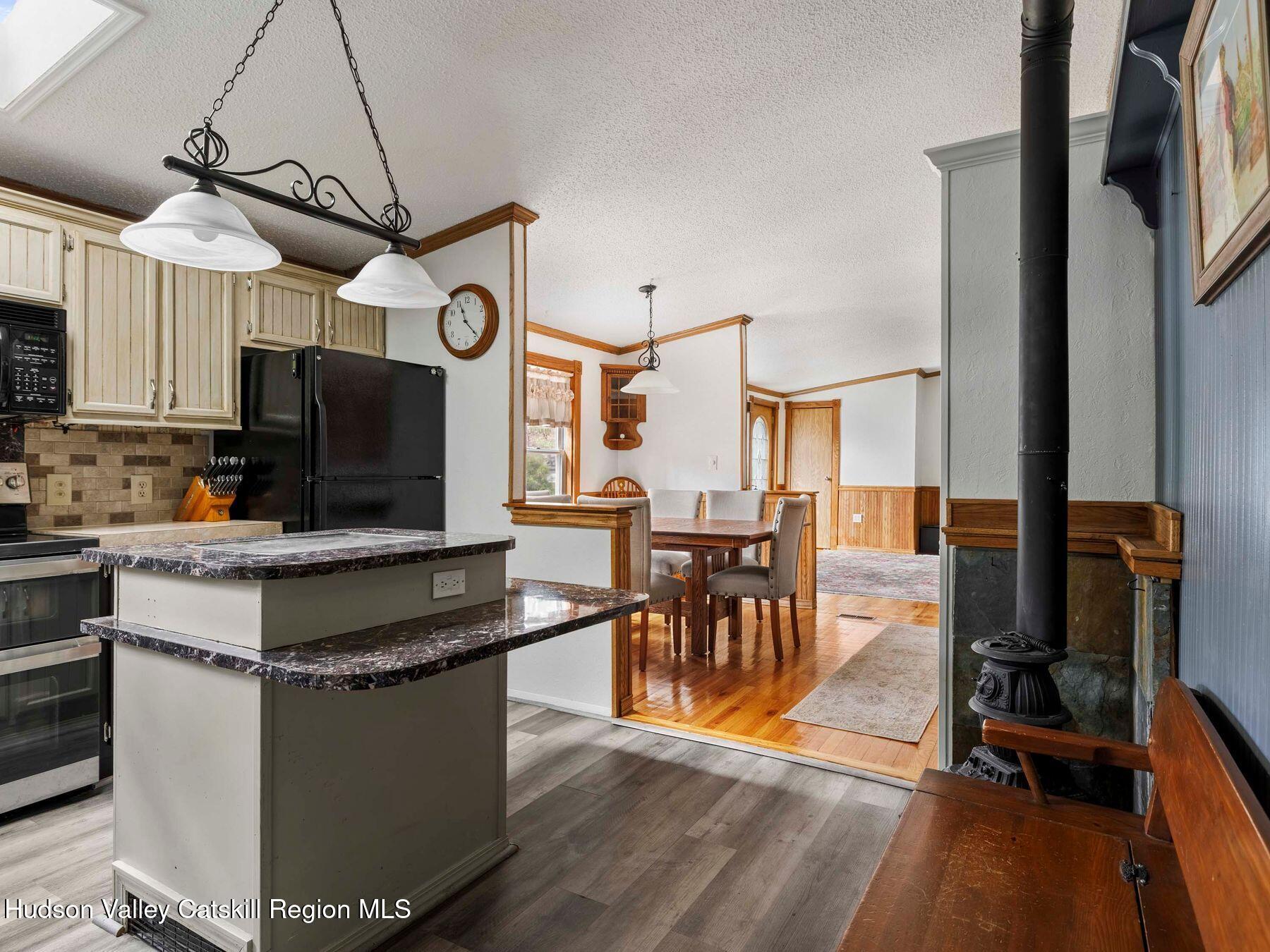 382 Cairo Junction Road Catskill, NY 12414 - Photo 8 of 38 a kitchen with stainless steel appliances granite countertop a stove top oven a sink dishwasher a dining table and chairs with wooden floor