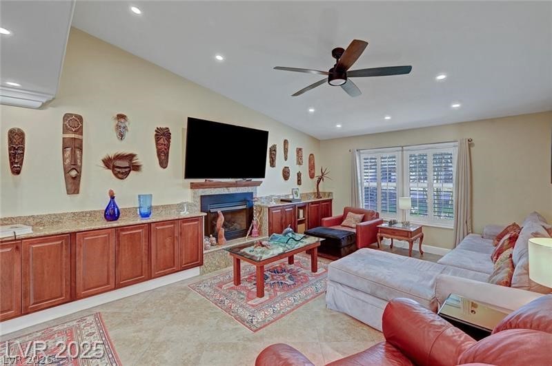 2410 Doherty Way Henderson, NV 89014 - Photo 13 of 63 Living area with ceiling fan, recessed lighting, a fireplace with raised hearth, and vaulted ceiling