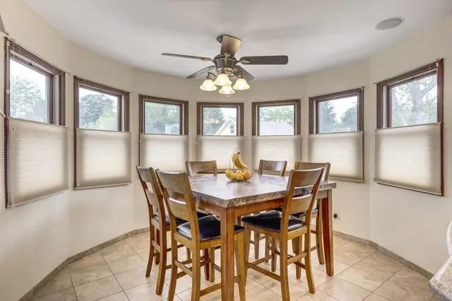 a view of a dining room with furniture a chandelier and a window