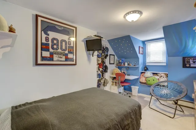 a bedroom with bed and a lamp on dresser