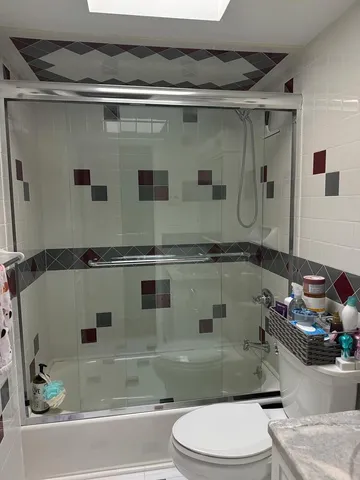 a bathroom with a granite countertop sink a toilet and shower