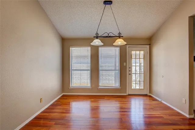 a view of a room with wooden floor chandelier and window