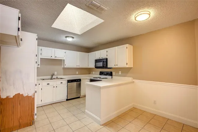 a kitchen with granite countertop a sink and a stove top oven