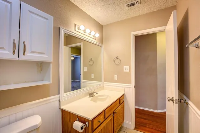 a bathroom with a sink a toilet and a mirror