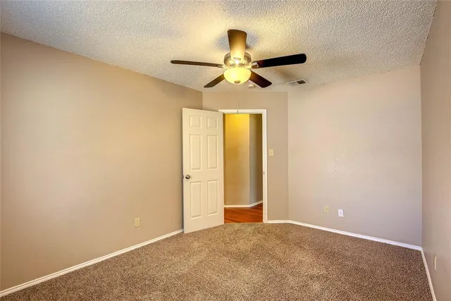 an empty room with a ceiling fan and a window