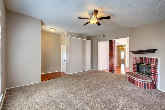 a view of empty room with fireplace and fan