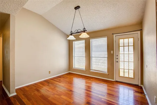 a view of a room with wooden floor and windows