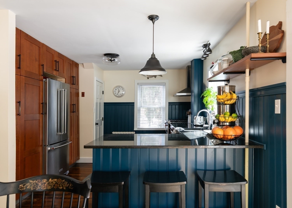 501 Spring Street Hanson, MA 02341 - Photo 5 of 32 a kitchen with stainless steel appliances granite countertop a refrigerator a stove and a wooden floor