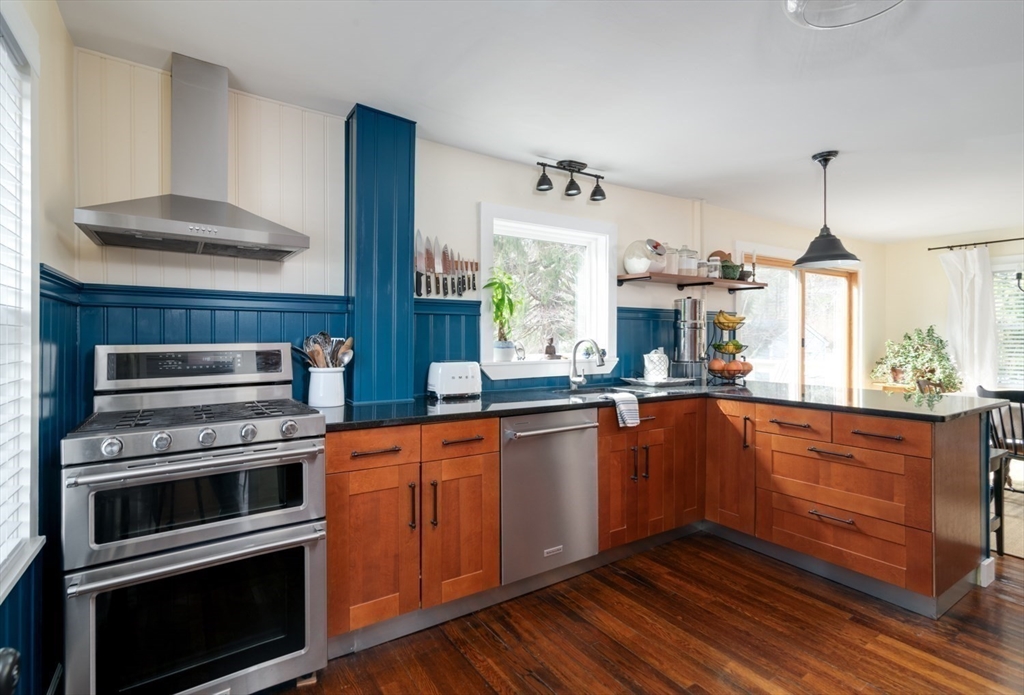 501 Spring Street Hanson, MA 02341 - Photo 6 of 32 a kitchen with stainless steel appliances kitchen island granite countertop a stove a sink and a wooden floors