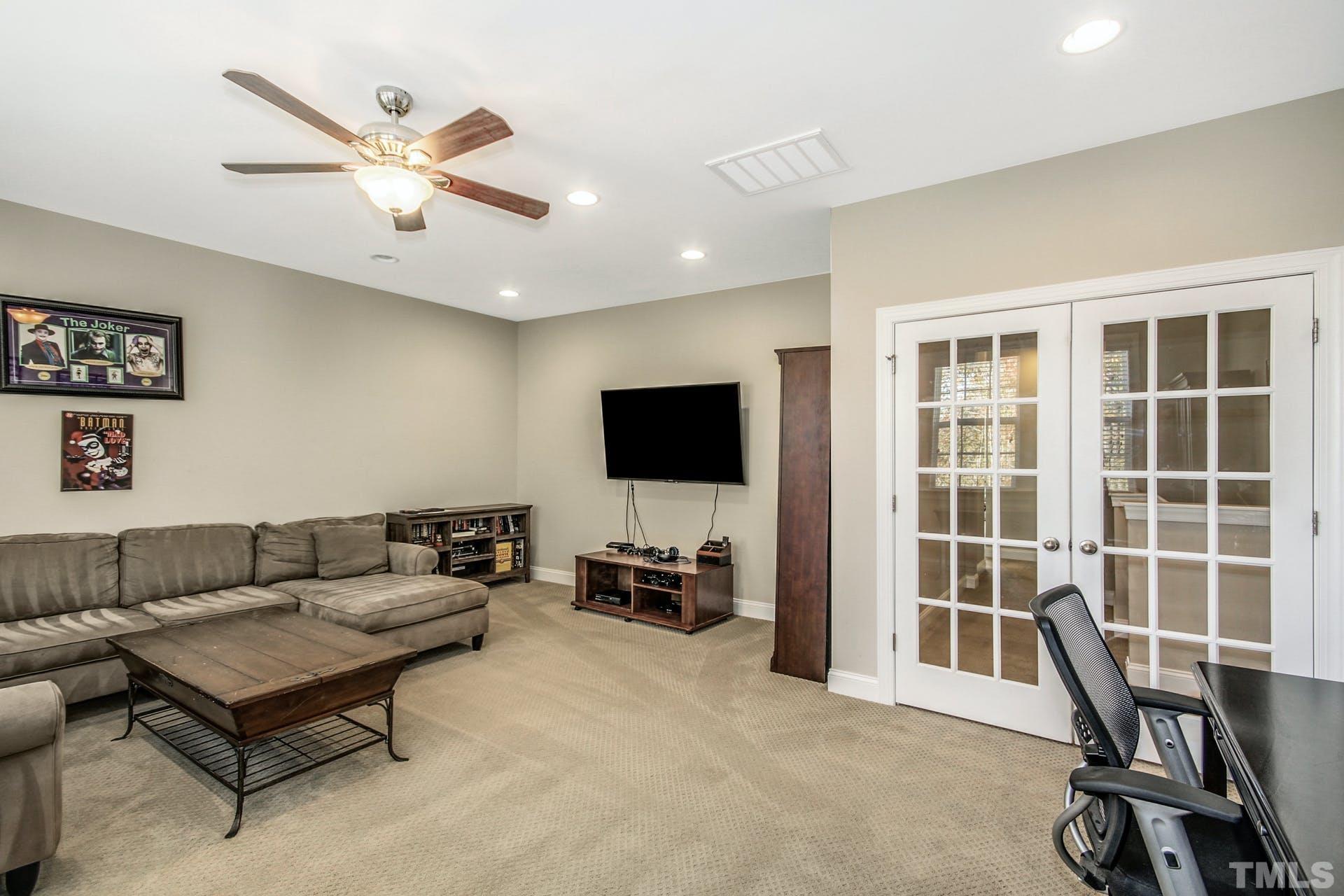 2013 White Rocks Road Wake Forest, NC 27587 - Photo 23 of 36 a living room with furniture a ceiling fan and a flat screen tv