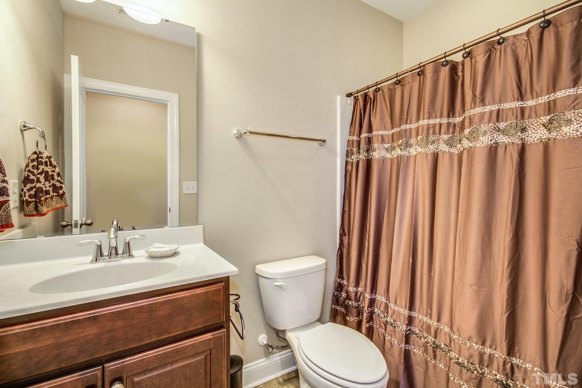 2013 White Rocks Road Wake Forest, NC 27587 - Photo 30 of 36 a bathroom with a toilet a sink and a mirror