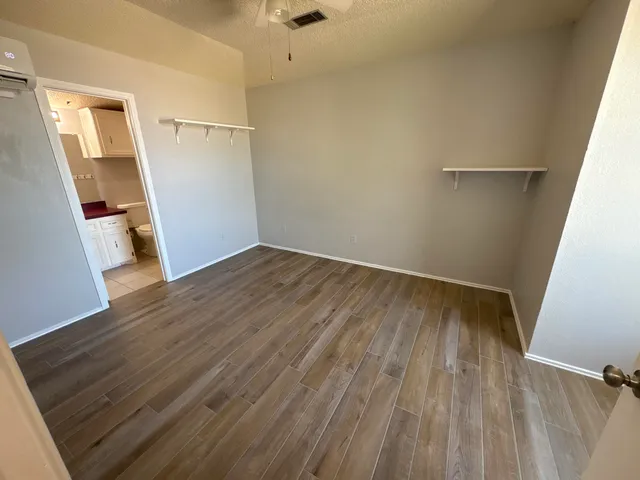 an empty room with wooden floor and windows