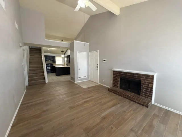 a view of empty room with wooden floor and fireplace