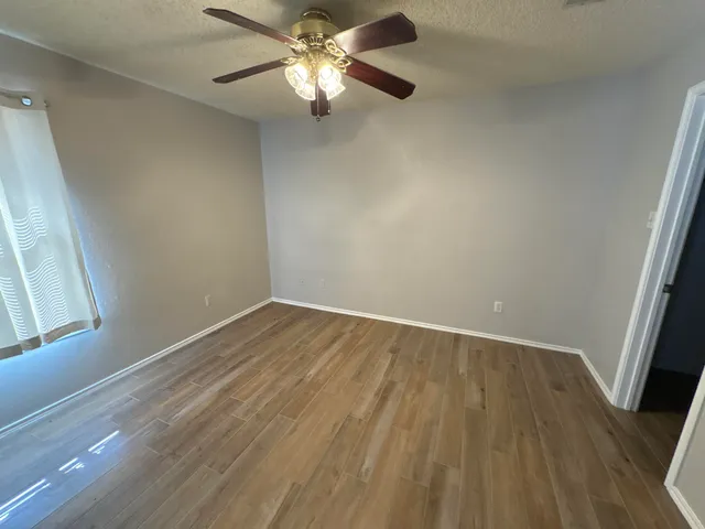wooden floor in an empty room with a window