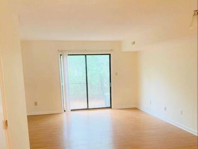 2104 Spring Forest Road, Unit 2104 Raleigh, NC 27615 - Photo 6 of 9 an empty room with wooden floor and windows