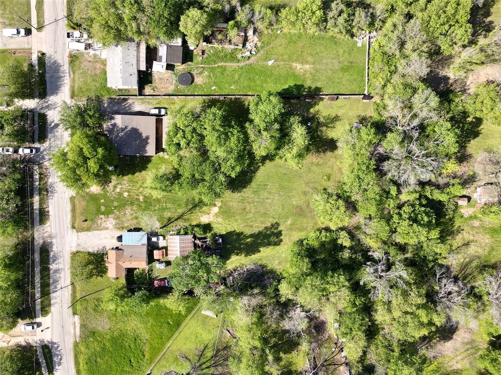 an aerial view of residential houses with outdoor space and trees
