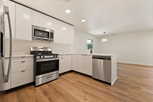a kitchen with stainless steel appliances a stove microwave and sink