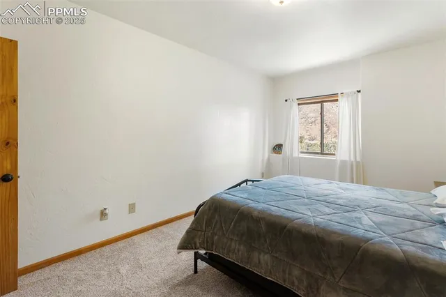 a bed sitting in a bedroom next to a window