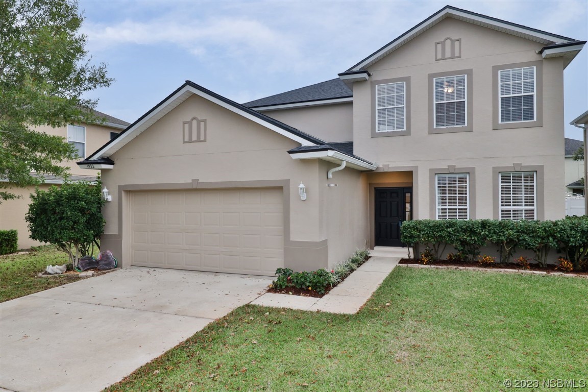 1922 Cove Point Road Port Orange, FL 32128 - Photo 1 of 54 a front view of a house with a yard and garage