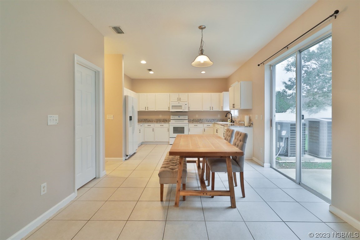 1922 Cove Point Road Port Orange, FL 32128 - Photo 11 of 54 a dining room with stainless steel appliances a table and chairs