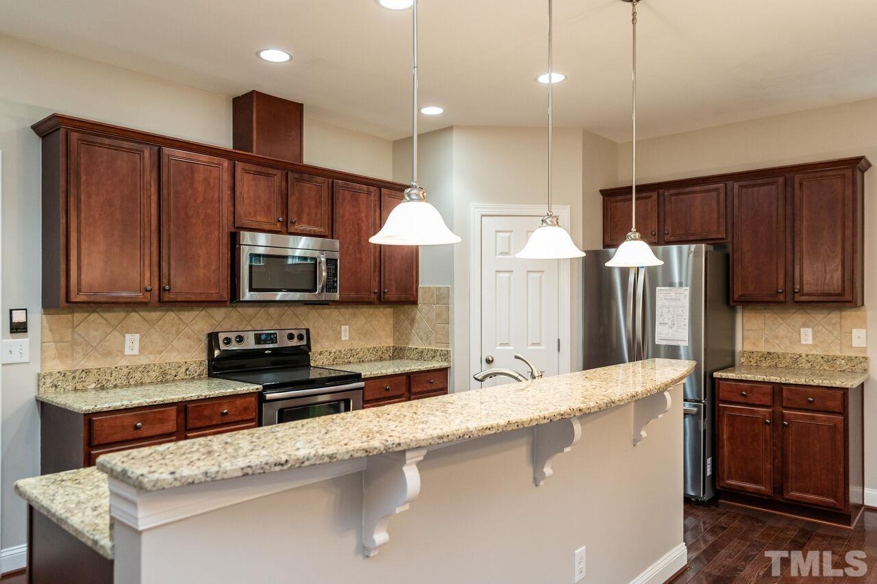 524 Bouree Circle Raleigh, NC 27606 - Photo 14 of 34 a kitchen with stainless steel appliances granite countertop a sink a stove and a refrigerator