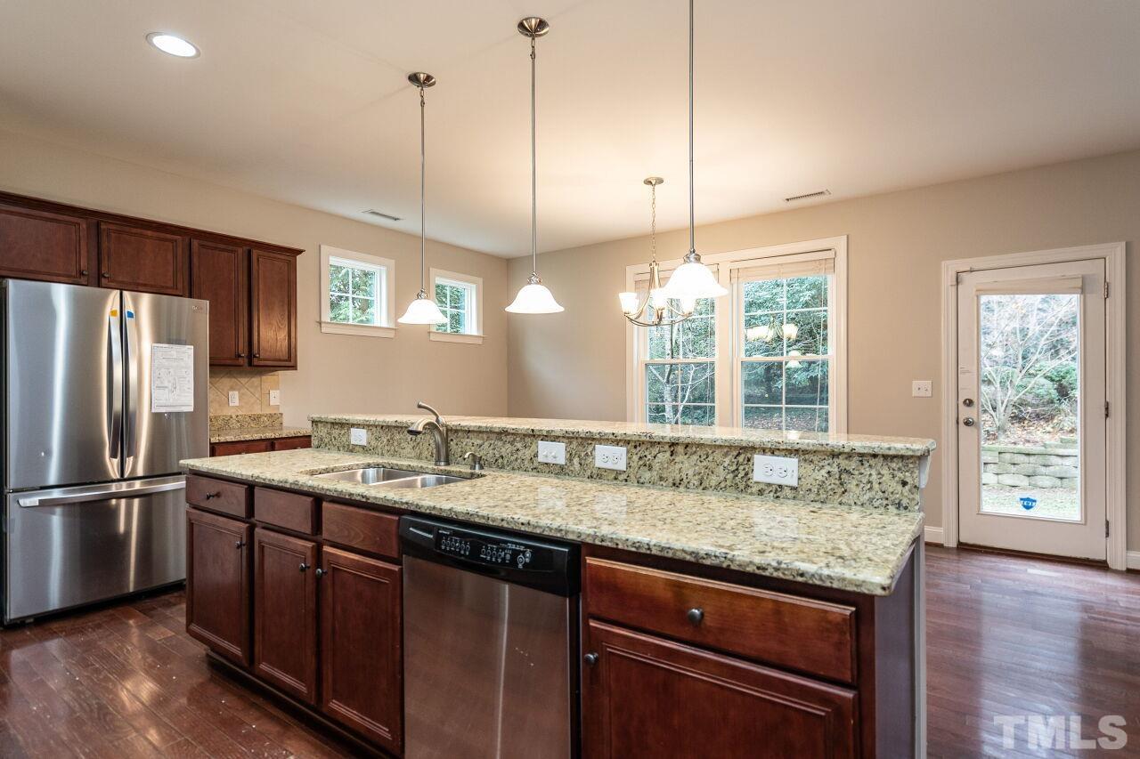 524 Bouree Circle Raleigh, NC 27606 - Photo 16 of 34 a kitchen with granite countertop a sink and refrigerator